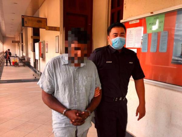 Suresh (kiri) dibawa keluar dari Mahkamah Sesyen Kuala Lumpur hari ini.