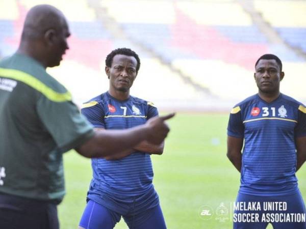 Zainal Abidin memberi arahan kepada dua pemainnya pada sesi latihan.