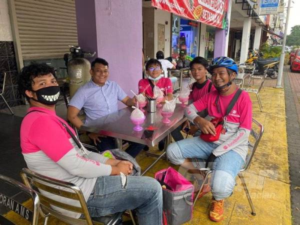 Sanjeevan (dua dari kiri) bersama penghantar makanan termasuk Marcus (tengah).