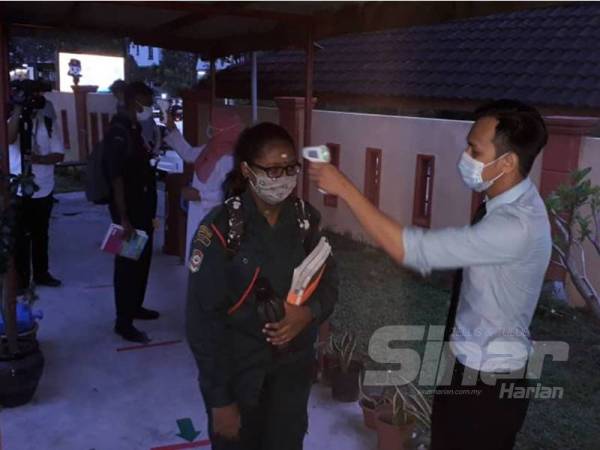 Pemeriksaan suhu badan dilakukan terhadap pelajar yang hadir memulakan sesi persekolahan di SMK Seri Perling, Taman Perling, Johor Bahru, hari ini.