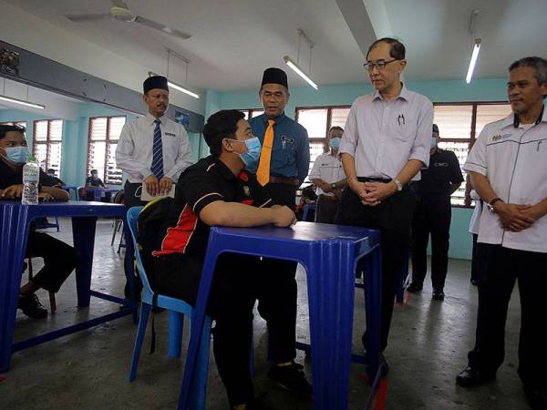 Dr Mah Hang Soon (dua, kanan) beramah mesra dengan pelajar Rashdan Syahmi Ramli ketika tinjauan hari pertama pembukaan semula sekolah pasca Perintah Kawalan Pergerakan (PKP). -Foto Bernama