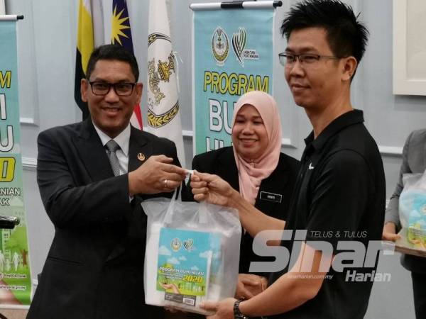 Ahmad Faizal menyampaikan kit bumi hijau kepada salah seorang penerima pada program Bumi Hijau Negeri Perak hari ini.