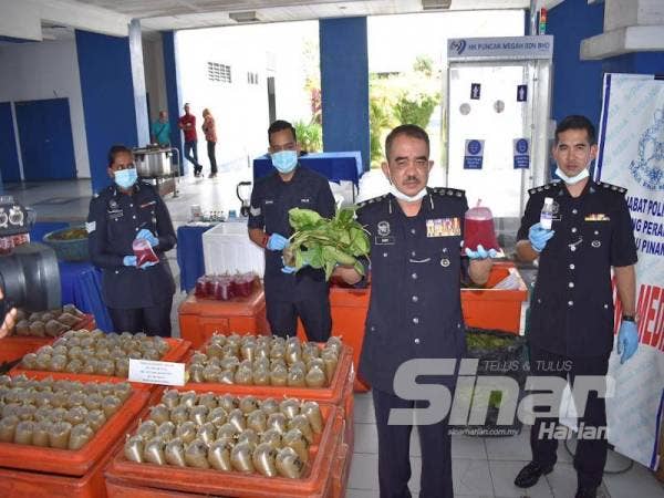 Noorzainy (tengah) menunjukkan bungkusan ketum yang dirampas.