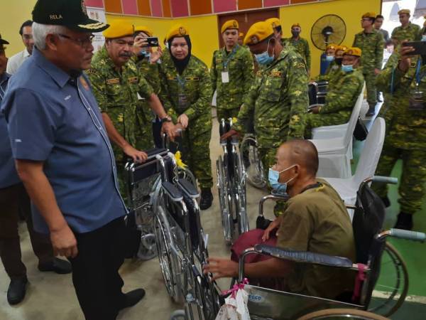 Hamzah menyampaikan kerusi roda kepada anggota Rela yang hilang keupayaan pada Majlis Menteri Dalam Negeri Bersama Rela Chini hari ini.