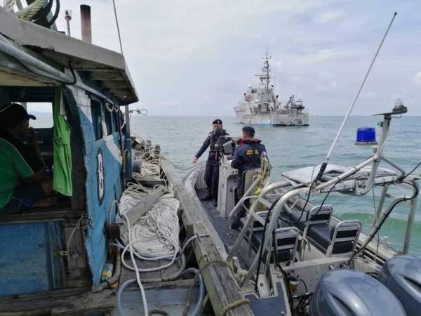 Anggota APMM membantu tiga nelayan yang tersadai di tengah laut selepas bot yang dinaiki rosak dan bocor di selatan Sungai Rengit, Kota Tinggi, Johor semalam.