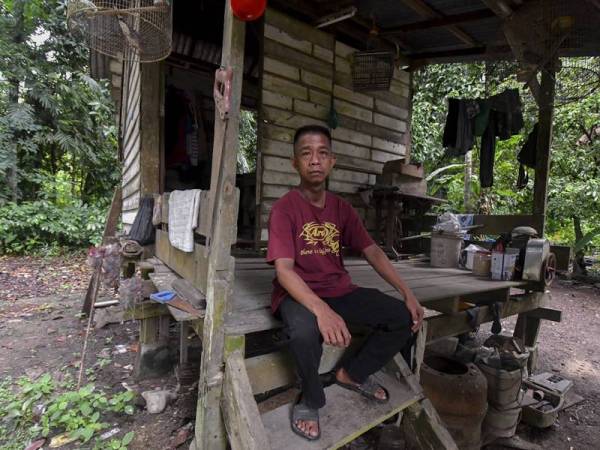 Alias Abdullah duduk di hadapan pintu bangsal yang terletak di Kampung Padang Taman, Jalan Perol Peringat di sini. - Foto Bernama