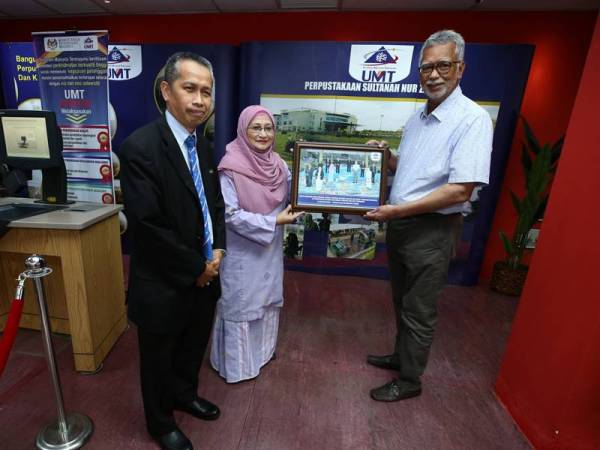 Shamsul Azhar (kanan) menerima cenderahati daripada Dr Nor Aieni. - Foto UMT