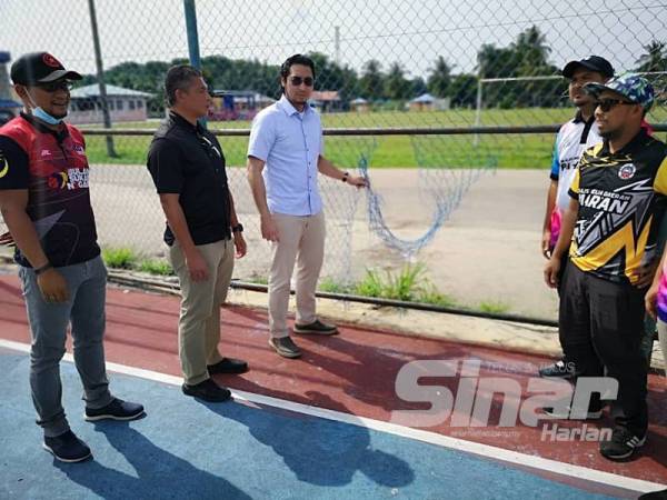 Wan Ahmad Fayhsal (tiga dari kiri) melihat keadaan padang futsal yang rosak di Kampung Baru Salong Chini.