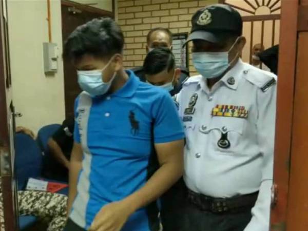 Salah seorang tertuduh dibawa keluar dari kamar mahkamah oleh anggota trafik bertugas selepas prosiding selesai.