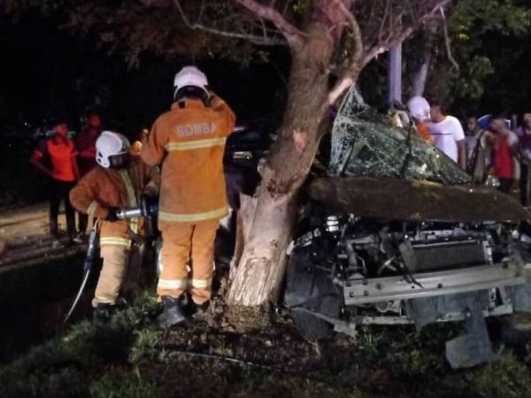 Anggota bomba membantu mengeluarkan mangsa tersepit dalam kejadian sebuah kereta merempuh pokok di Kampung Pecah Batu, Jalan Rawang di sini malam tadi.