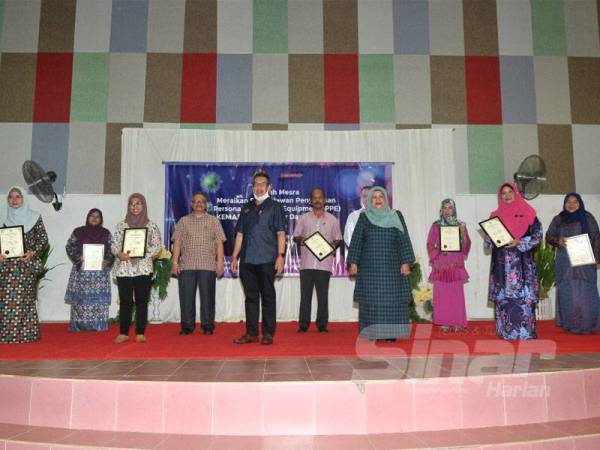 Abd Latif (lima dari kiri) bersama penyelaras Kemas pada Majlis Penyampaian Sijil Penghargaan kepada Sukarelawan Jahitan PPE di Dewan Masyarakat Felda Tenggaroh 5, Mersing semalam.