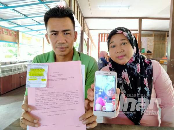 Mohd Hanief dan Azlin menunjukkan gambar Susilah dan dokumen yang perlu dilengkapkan.