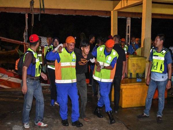 Salah seorang daripada 12 mangsa yang diselamatkan oleh bot nelayan lain selepas bot dinaiki terbalik dibawa ke jeti pangkalan Kemasin malam tadi.