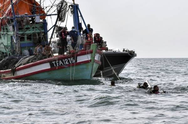 Anggota Unit Pasukan Penyelamat di Air (PPDA) Jabatan Bomba dan Penyelamat Malaysia (JPBM) Kelantan melakukan selaman untuk mencari mangsa bot karam yang masih hilang di Muara Kuala Kemasin, semalam. - Foto Bernama