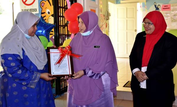 Siti Zailah menyampaikan sijil perakuan taska kepada Pengusaha Taska Sinarku Gemilang Cawangan Sekolah Tunas Bakti, Suhaili Othman (kiri) di Melaka, hari ini.
- Foto Bernama