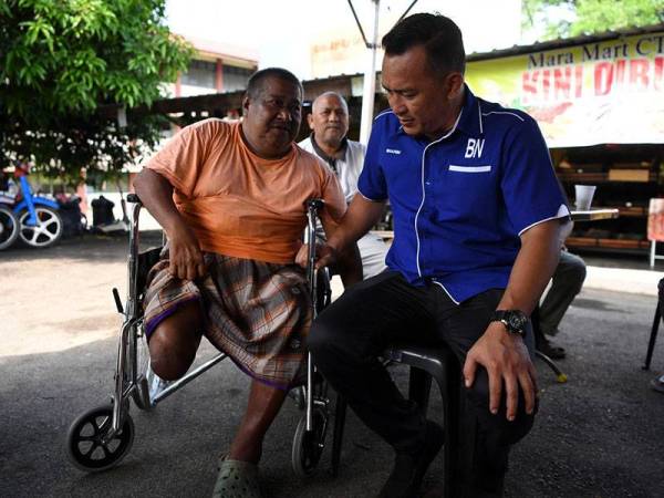 Calon Barisan Nasional (BN) Mohd Sharim Md Zain melihat kaki peneroka Wahid Yassin, 63, yang dipotong akibat kencing manis ketika Ziarah Kasih pengundi Felda Chini Timur Satu, dalam kempen Pilihan Raya Kecil (PRK) Dewan Undangan Negeri (DUN) Chini N.23 hari ini.