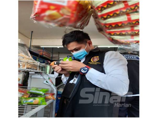 Anggota penguat kuasa memeriksa tarikh luput bungkusan makanan di kedai runcit di Batu Maung, Bayan Lepas pagi tadi..