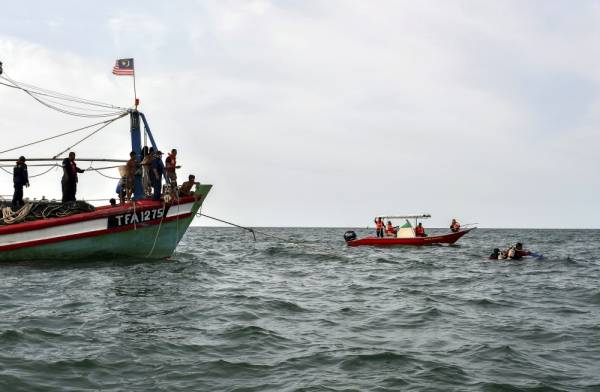 Anggota Unit Pasukan Penyelamat di Air (PPDA) Jabatan Bomba dan Penyelamat Malaysia (JPBM) Kelantan melakukan selaman untuk mencari mangsa bot karam yang masih hilang di Muara Kuala Kemasin. - Foto Bernama