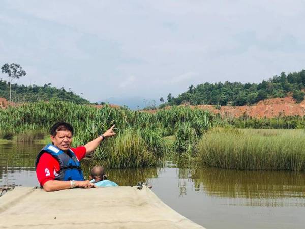 Zainul Hisham menunjukkan salah satu lokasi penerokaan tanah bagi aktiviti perlombongan yang terlalu menghampiri tasik.
