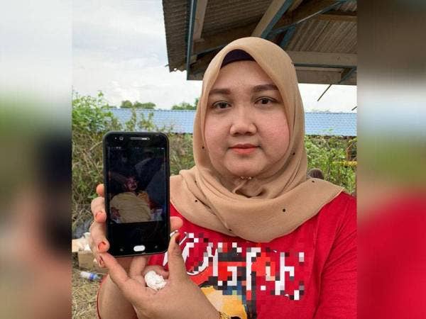 Cik Normas menunjukkan foto Che Wadi di telefon bimbitnya.