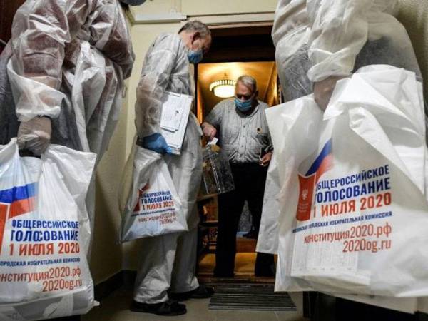 Pegawai pilihan raya membawa beg berisi kertas undi di Rusia. - AFP