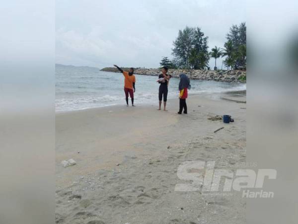 Penyelamat pantai wanita memberikan penerangan kepada pengunjung Pantai Pulau Kekabu.