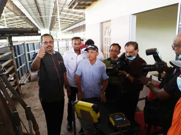 Ronald (tiga dari kiri) melihat proses menimbang lembu ketika lawatan kerja ke ladang PPM Jalan Kluang-Mersing semalam.