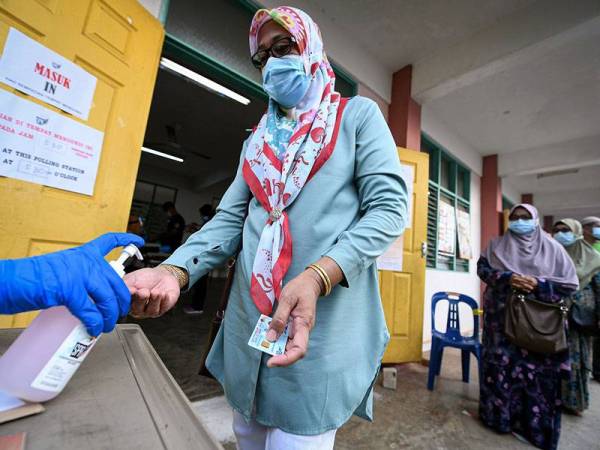 Pengundi kelihatan menggunakan pembersih tangan (hand sanitize) sebelum mengundi pada Pilihan Raya Kecil (PRK) N.23 Dewan Undangan Negeri (DUN) Chini di Kelas Al-Quran dan Fardu Ain (KAFA) Felda Chini 3 hari ini.