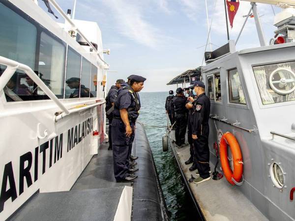 Pengarah Maritim Negeri Kelantan (APMM) Kepten Muhd Nur Syam Asmawie Yaacob (kiri) bersama Ketua polis marin diraja Thailand (Tak Bai) Police Major Thampapol Chauncham membuat rondaan di persempadanan bersama Polis Marin Malaysia di perairan sungai Golok sempadan Malaysia-Thailand bagi mengesan dua lagi mangsa hilang dalam tragedi bot terbalik dan karam di perairan Bachok yang memasuki hari keenam hari ini. - Foto Bernama