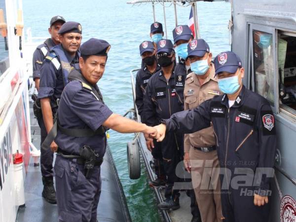 Muhd Nur Syam (kiri) bersalaman dengan Thampapol Chauncham ketika mengadakan kerjasama dalam operasi SAR di perairan sempadan dua-dua negara hari ini. 