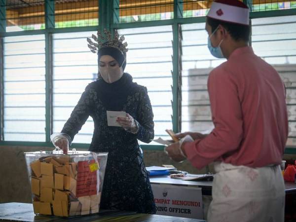 Pengantin adik beradik, Abdul Rahim Idris (kanan) dan adiknya Siti Hajar Idris (kiri) semasa mengundi di Kelas Al-Quran dan Fardu Ain (KAFA) Felda Chini 3 hari ini.
Foto: Bernama