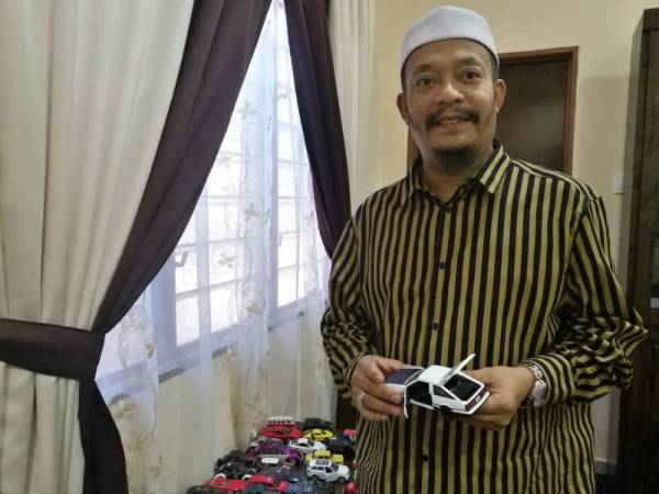 Mohd Kazim menunjukkan salah satu kereta mainan kesayangan yang dikumpul sebagai hobi mengisi masa lapang. 