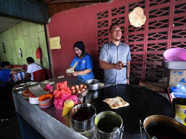 Mohd Sharim cuba memasak roti canai semasa berjumpa dengan penduduk setempat di Felda Chini 3 hari ini selepas memenangi PRK DUN Chini semalam. - Foto Bernama
