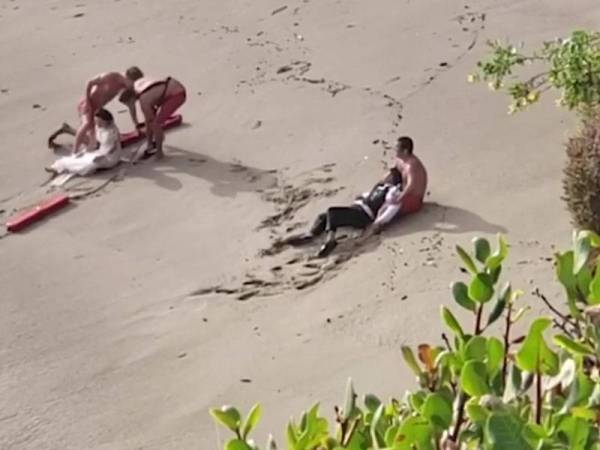 Pasangan pengantin yang selamat selepas nyaris lemas dihanyutkan ombak besar. FOTO: ABC