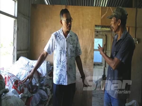 Sukry (kanan) menunjukkan arang tradisional yang dihasilkannya kepada Rosol. 