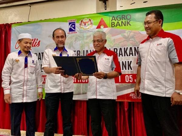Iskandar Zurkarnain (dua dari kiri) dan Syed Ibrahim (dua dari kanan) melihat kontrak perjanjian yang ditandatangani di Dewan Merak Kesedar Hotel Travel & Tours, Gua Musang semalam.
