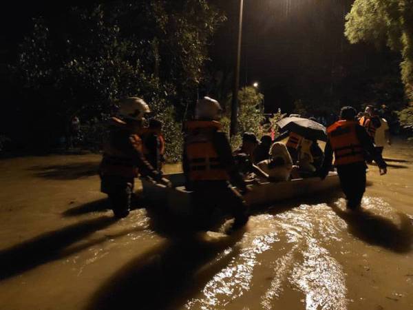 Anggota dari Balai Bomba dan Penyelamat Bidor membantu proses pemindahan penduduk ke PPS malam tadi.