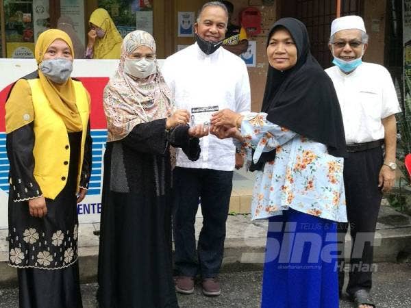 Amiruddin (tengah) menyaksikan penyerahan pelitup muka kepada wakil penerima kempen ‘Masks4all’ CNI di Pusat Gaya Hidup Sihat CNI Changlun hari ini.