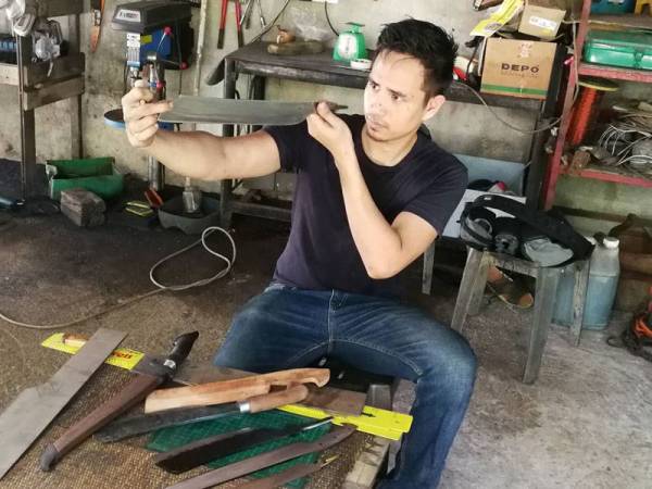 Lokman Nurhakim menyiapkan tempahan sedang menyiapkan pisau.