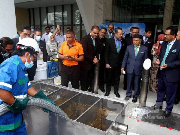 Tuan Ibrahim meninjau operasi perkhidmatan pengosongan sistem perangkap lemak, minyak dan gris (FOG) dalam majlis pelancarannya hari ini. - Foto Asril Aswandi Shukor