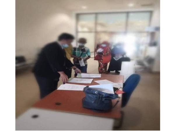 Enam individu sedang melakukan pengesahan dokumen di Mahkamah Majistret Khas Trafik. - Foto ehsan MPK