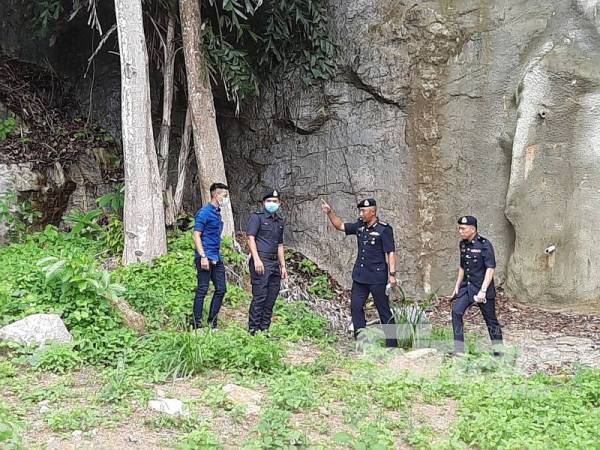 Soffian (dua dari kanan) menunjukkan lokasi penemuan tulang, barang peribadi dan baju mangsa ditemui.