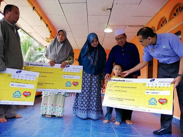 Mohammed Azman (kanan) menyampaikan cek Faedah Pengurusan Mayat dan Pencen Penakat kepada kedua-dua waris Allahyarham.