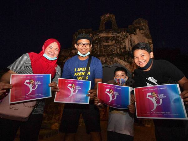 Pengunjung dari Johor ketika mengunjungi Kota A Famosa memegang flash kad sempena sambutan Ulang Tahun Rukun Negara ke-50.