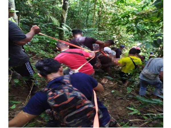 Mayat mangsa dibawa turun dengan menggunakan ‘skop strecher’ melalui kawasan curam dan licin di Kampung Kuala Temin.