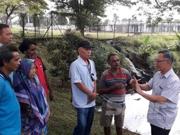 Steven (kanan) memberi penjelasan kepada penduduk setempat berkenaan masalah pencemaran bau dari loji rawatan air sisa di Taman Kota Masai, Pasir Gudang semalam.