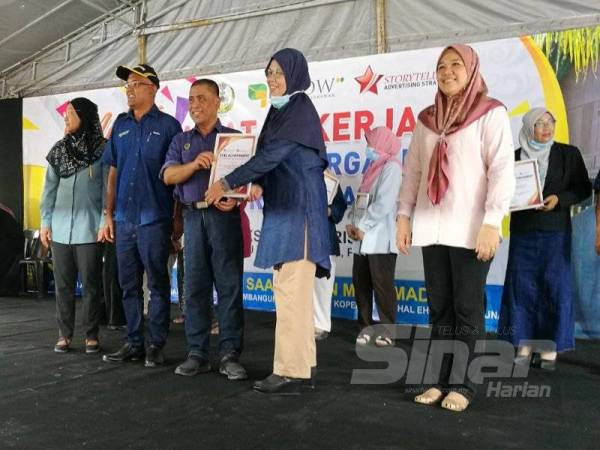 Saarani (tengah) menyampaikan Anugerah STAR kepada seorang usahawan yang cemerlang ketika Covid-19 di Kompleks Desa Warisan IGROW, Kampung Gajah, hari ini.