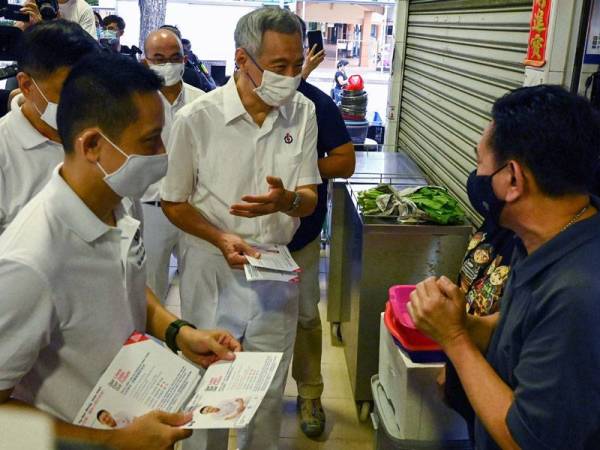 Perdana Menteri Singapura, Lee Hsien Loong (tengah) yang juga Setiausaha Agung parti pemerintah, Parti Tindakan Rakyat (PAP) bertemu penduduk ketika berkempen baru-baru ini. - Foto: AFP