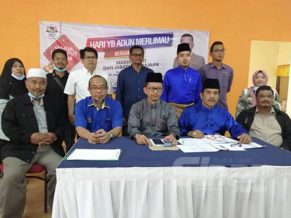 Roslan (duduk, tiga dari kanan) bersama jawatankuasa program dan agensi kerajaan pada Hari Bertemu Masyarakat DUN Merlimau di Kampung Ayer Merbau, Jasin hari ini.