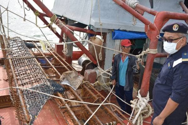 Anggota APMM memeriksa peralatan menangkap gamat di atas bot nelayan Vietnam.